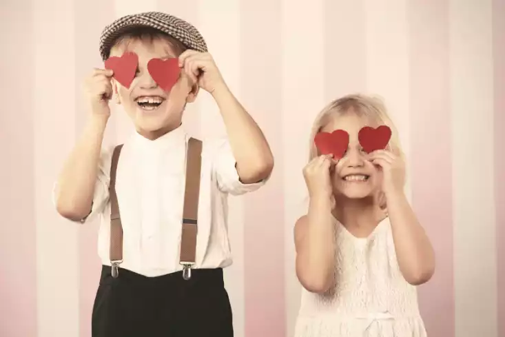 Histoire de la fondation Solacroup - Photo de deux enfants rieurs qui portent des papiers en forme de coeur à leurs yeux